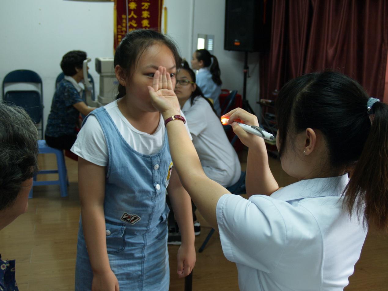 张大夫为小姑娘进行眼部检查